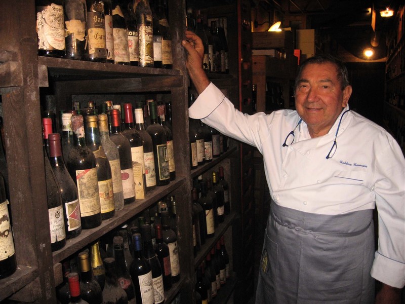 Galdino Gianesin, nella cantina della Trattoria Isetta, uno dei luoghi che lui amava di più. E sotto una foto di famiglia, con Galdino al centro