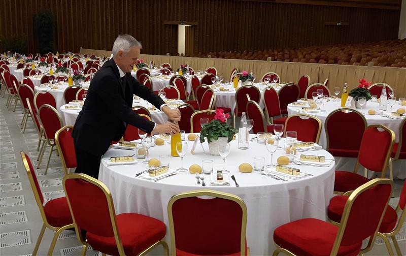 Sergio Dussin nell'aula Paolo VI del Vaticano. In basso, due momenti del pranzo (foto Ansa)